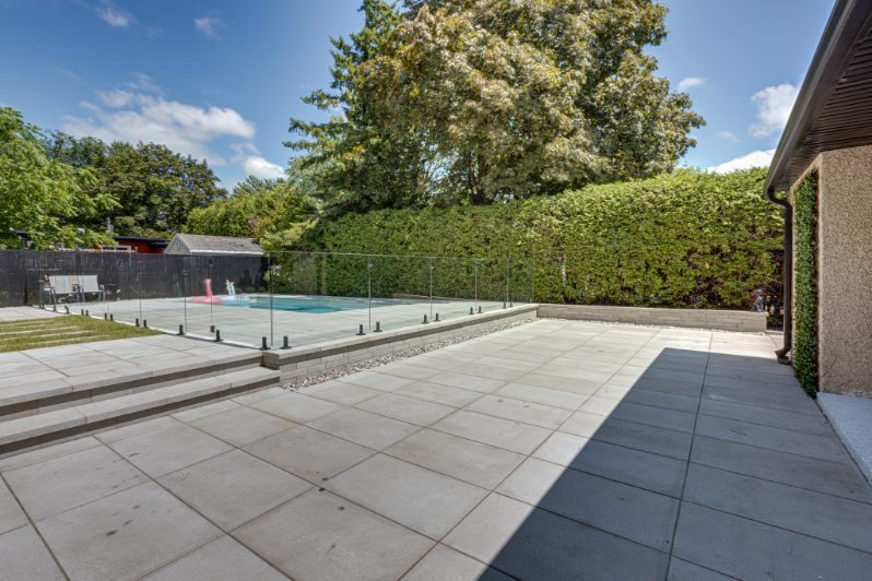 piscine-terrasse-pave-uni-cloture-verre-haie-amenagement